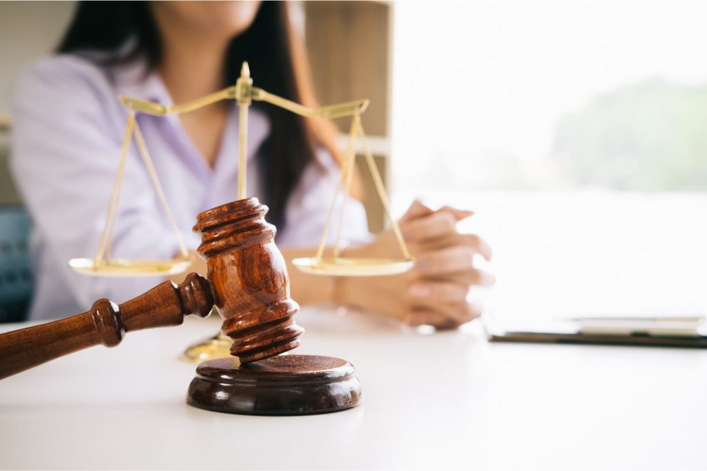 a close up of a gavel with a lawyer in the background
