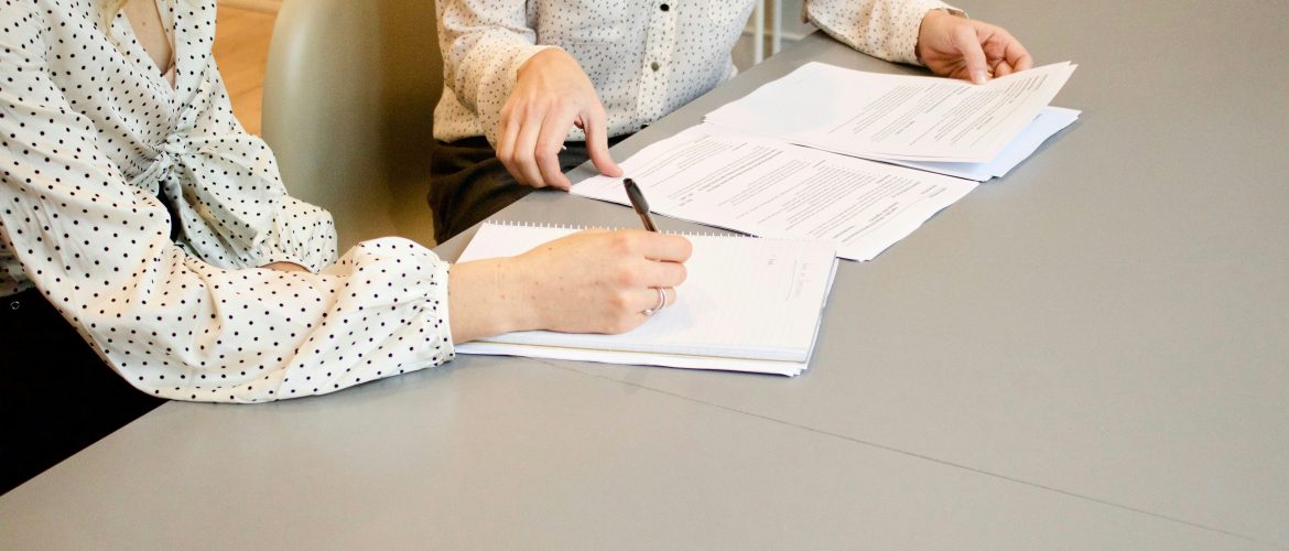attorney-reviewing-paperwork-client Lawyer reviewing legal documents with client