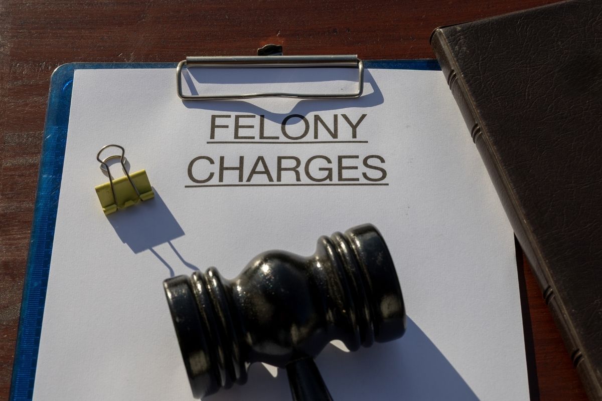 a gavel on top of a folder labeled "felony charges"