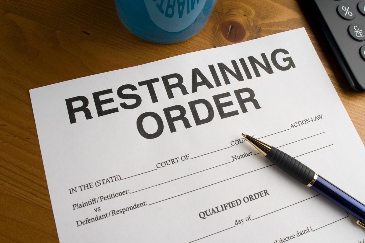 a blank restraining order document with a pen on it