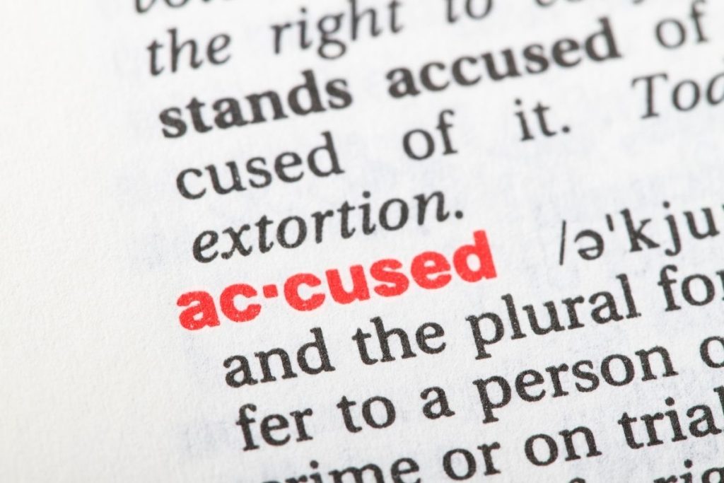 text in a dictionary highlighting the word "accused" in red