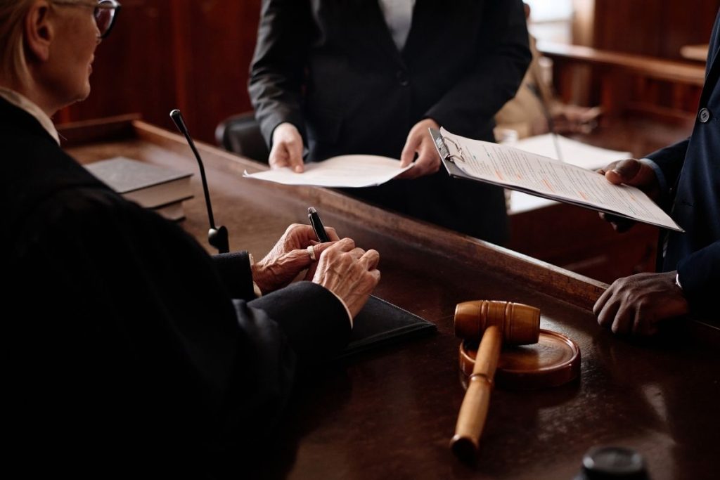 a judge receiving evidence from a lawyer in a courtroom